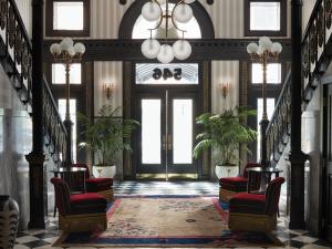 een hal met twee stoelen en een deur met ramen bij Maison Metier, in the Unbound Collection by Hyatt in New Orleans