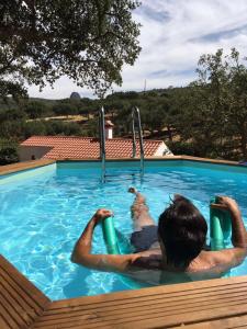 un hombre está en una piscina en Azeite de Marvão, Olivoturismo casa Mestre do Lagar, en Marvão