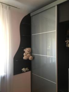 een teddybeer op een plank in een kamer bij Imanta Apartment in Daugavpils