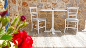 two white chairs and a table and a table at Nautilus Dome in Fira