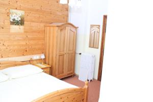 a bedroom with a bed and a wooden wall at Gasthof Edelweiss in Semmering