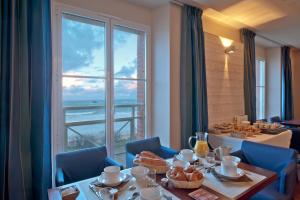 une salle à manger avec une table et une grande fenêtre dans l'établissement Residence Reine Marine, à Saint-Malo