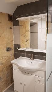 a bathroom with a white sink and a mirror at Gite de la Haie in Apremont