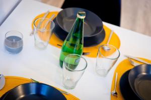 a table with a green bottle and glasses on it at Apartament Kalinka in Nysa