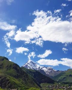 - une vue sur une montagne enneigée sous un ciel nuageux dans l'établissement Sunny Mountain House, à Kazbegi