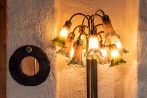 un lampadario pendente appeso a un muro accanto a uno specchio di Fado Cottage Kenmare a Kenmare