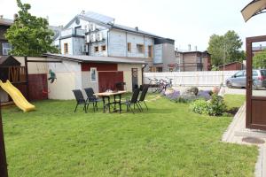 a yard with a table and chairs and a house at Windrose in Liepāja