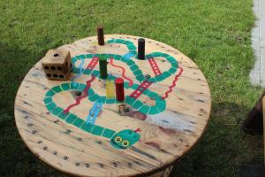 a wooden table with a toy train on the grass at Windrose in Liepāja