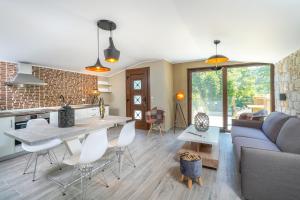 cocina y sala de estar con sofá y mesa en Natura Bungalows, en Limenas