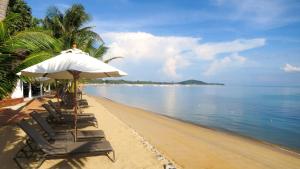 een strand met stoelen en een parasol en de oceaan bij Paradise Beach Resort, Koh Samui - SHA Extra Plus in Mae Nam