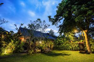 乌布Ananda Ubud Resort的一个带蓝色屋顶的房子的花园