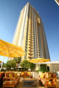 um edifício alto com cadeiras e guarda-sóis em frente a um edifício em Luxury Suites International at The Signature em Las Vegas