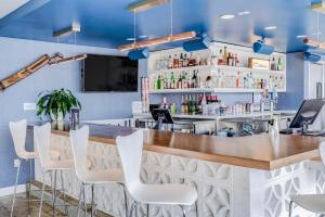 een bar in een restaurant met witte stoelen bij Downtowner Boutique Hotel in Las Vegas