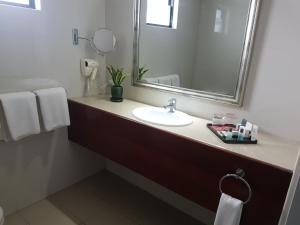 y baño con lavabo y espejo. en PADDY'S HOTEL & APARTMENTS, en Port Moresby