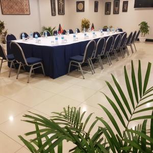 una mesa larga en una habitación con sillas y plantas en PADDY'S HOTEL & APARTMENTS, en Port Moresby