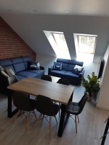 sala de estar con mesa y sofá azul en Apartamenty Platinum 2, en Łukęcin