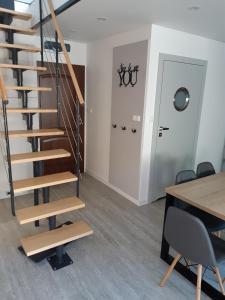 una escalera en una habitación con mesa y sillas en Apartamenty Platinum 2, en Łukęcin