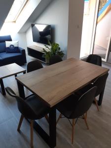 sala de estar con mesa de madera y sillas en Apartamenty Platinum 2, en Łukęcin