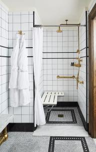 een badkamer met een douche met witte tegels bij The Ludlow Hotel in New York