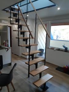 a spiral staircase in a living room with a chair at Apartamenty Platinum in Łukęcin