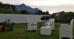 a group of white chairs and a table with wine glasses at Il fiore di loto in San Felice Circeo