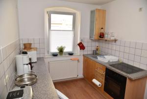 una pequeña cocina con fregadero y ventana en Ferienwohnung Zentrum, en Neuruppin