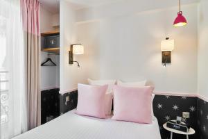 a bedroom with a bed with pink pillows at Hôtel Augustin - Astotel in Paris