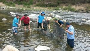 un gruppo di persone in piedi in un fiume con l'aigatore di Fermata Pension a Pyeongchang