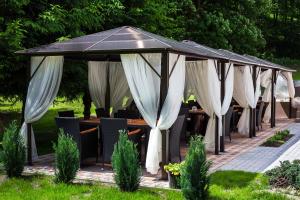 um gazebo com mesas e cortinas brancas em Honour and Grace Hotel em Jáchymov