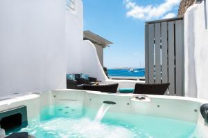 een jacuzzi met uitzicht op de oceaan bij Riva Suites - Adults Only in Mykonos-stad