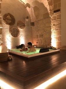 Ein Mann und eine Frau in einer Badewanne in der Unterkunft Le Fornaci Imperial Lodge & Spa in Gravina in Puglia