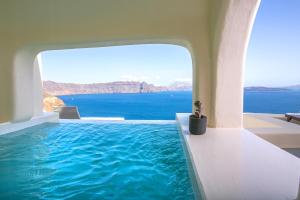 een zwembad met uitzicht op de oceaan bij Aloia Villas in Oia