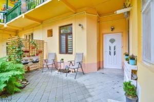 a patio with chairs and a white door at Via Del Centro in Sibiu