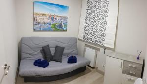 a small room with a couch with blue pillows at Apartamento Barajas. Aeropuerto/Ifema in Madrid