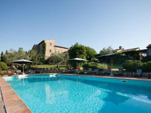 a large swimming pool with chairs and umbrellas at Tenuta Di Canonica in Todi