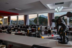 un ristorante con tavoli, sedie e statua di Hotel del Sole a Pompei