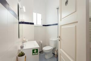 a white bathroom with a toilet and a sink at MouraLua in Sintra