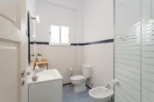 a white bathroom with a toilet and a sink at MouraLua in Sintra