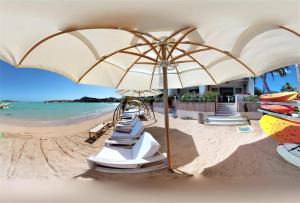 einen Strand mit einer Reihe von Stühlen und einem Sonnenschirm in der Unterkunft Hotel Les Ondines Sur La Plage in Gustavia