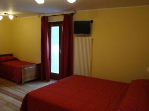 a bedroom with two beds and a sliding glass door at Hotel Le Petit Abri in Champoluc