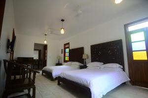 a bedroom with two beds and a window at Lanna Ban Hotel in Puerto Viejo