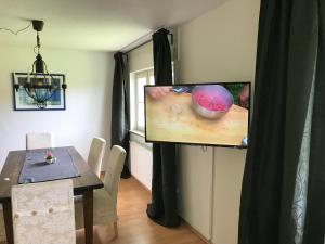 una sala da pranzo con tavolo e un dipinto di una ciotola di Ferienwohnung Hesselbach a Oberkirch