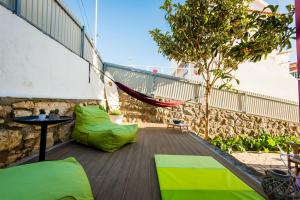 balkon z zielonymi poduszkami i hamakiem w obiekcie Hostel & Surfcamp 55 w mieście Ericeira