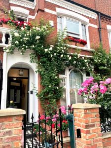 une maison en briques rouges avec des fleurs roses et blanches sur elle dans l'établissement Georgiana's Guesthouse, à Londres