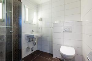 a white bathroom with a toilet and a sink at Thon Partner Hotel Victoria Hamar in Hamar