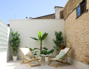 un patio con 2 sedie e piante in vaso di El Oasis de la Estafeta a Pamplona