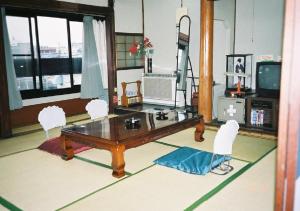 salon z drewnianym stołem i krzesłami w obiekcie Komecho Ryokan / Vacation STAY 36247 w mieście Imabari