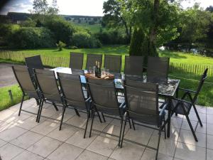 mesa de comedor y sillas con vistas a un patio en Au bord de l'Eau, en Bastogne