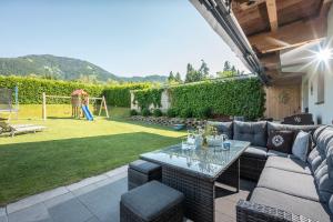 a patio with a couch and a table and a playground at Appartement Unterbering in Söll