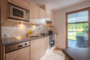 a kitchen with a sink and a microwave at Appartement Unterbering in Söll